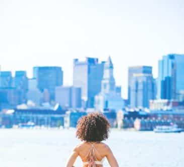 woman doing yoga facing calm body of water