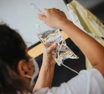 woman in white shirt holding clear plastic cup